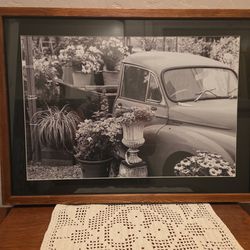 framed black and white photograph of a vintage truck decorated with flowers and plants,