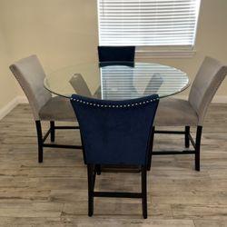 Round glass dining table 5 upholstered chairs (velvet-look, nailhead trim)