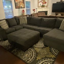 Very nice gray three-piece sectional with ottoman