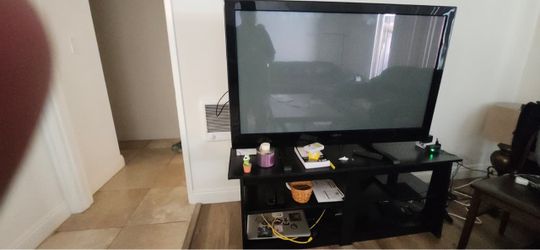 Large flat screen TV with black stand.