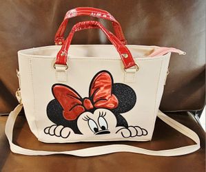 Disney Minnie Mouse handbag or tote bag featuring a prominent graphic of Minnie Mouse's face and bow. 