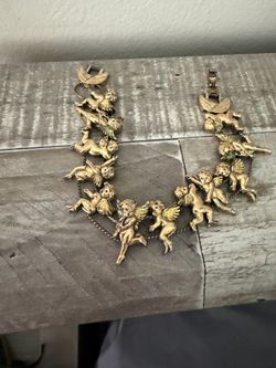 vintage gold-toned brass statement bracelet features numerous cherub links