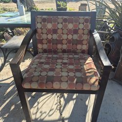 upholstered wooden accent chair featuring a geometric circle pattern fabric and dark wood arms and legs.
