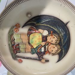 The product is a vintage M.l. Hummel. The plate is made of porcelain and features a raised, hand-painted designs. 