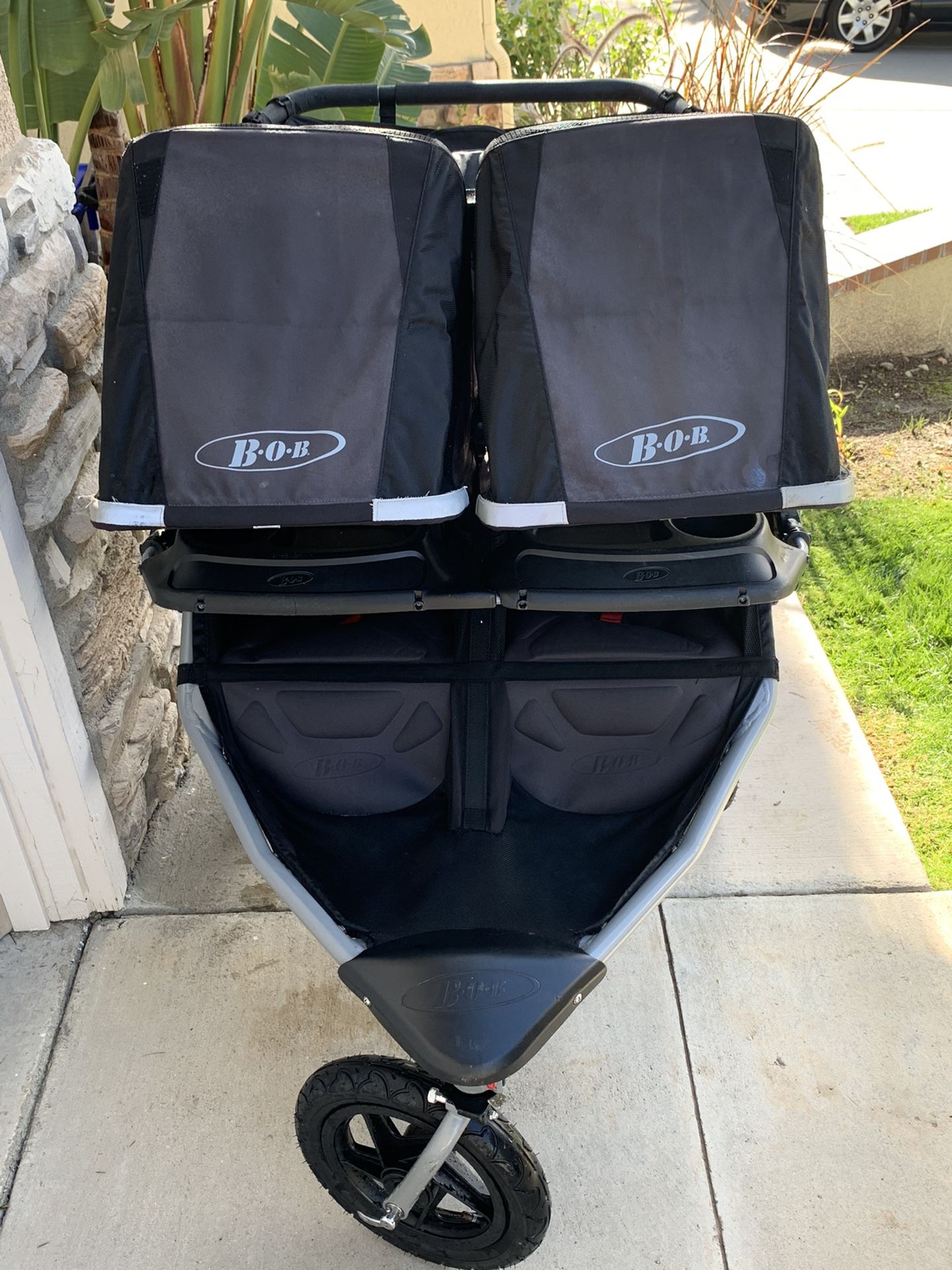 BLACK DOUBLE BOB JOGGING STROLLER W/HANDLE BAR & SNACK TRAY ATTACHMENT IN EXCELLENT CONDITION