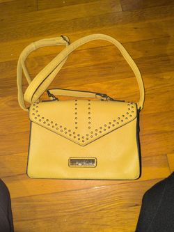 Marc jacobs  crossbody bag features a distinctive yellow faux leather exterior with a studded V-shaped flap and top handle