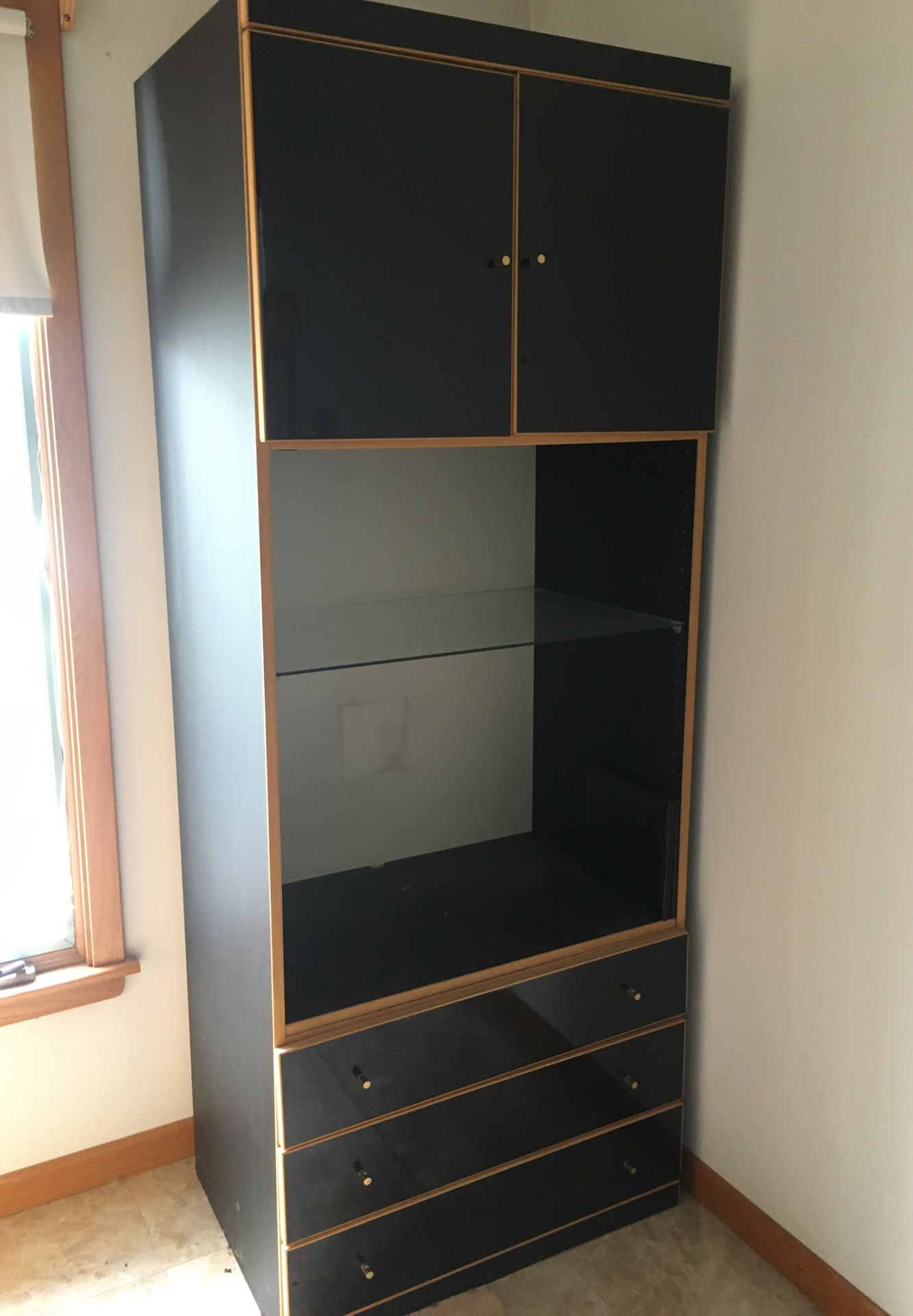 Black cabinet with three drawers, glass shelf & cabinet on top