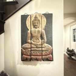Three-panel wooden wall art carving depicting a Buddha figure sitting in a meditative pose.