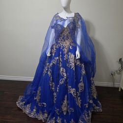 Gorgeous royal blue quinceañera dress. This is ROYAL/GOLD. Has intricate gold embroidery and sequins. Comes with a matching sheer cape. Model number C