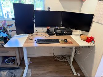 Electric desk with three computer monitors