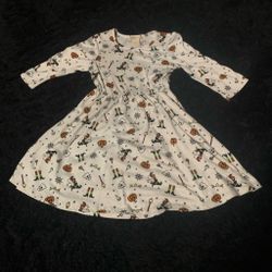 White Halloween dress with repeating witch, pumpkin, and broomstick graphics