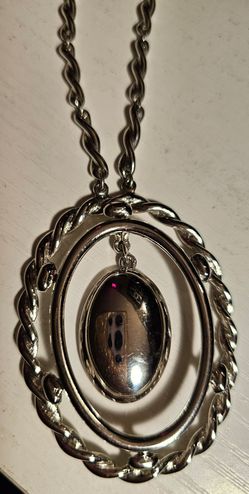 $45 Vintage MONET signed silver-tone oval pendant with a braided rope frame and chain.