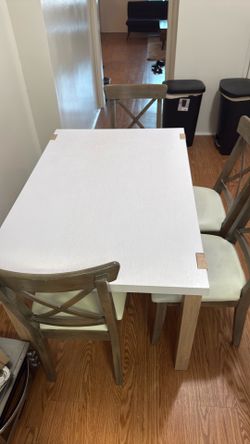 White wooden kitchen table with four chairs