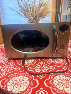 Oster 0.7 Cu. Ft. 700-Watt Microwave Oven in a chrome finish, featuring a retro design with a prominent handle.