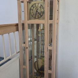 Ridgeway Pendulum Curio Grandfather Clock with a light wood finish and brass weights.   