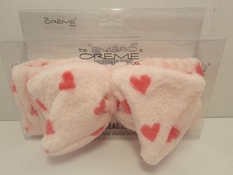 The Crème Shop Plush Spa Teddy Headyband in Pink with Red Hearts inside its clear packaging