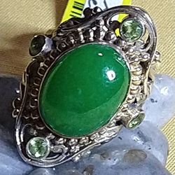 BURMESE GREEN JADE* AND (4) ,PERIDOT, ON EACH CORNER.. STERLING SILVER ELONGATED RING. SIZE 6.5. (R-15446) MEANING(S) BELOW