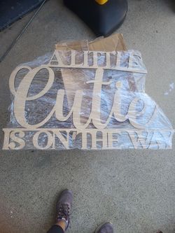 A little cutie is on the wood sign