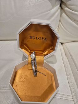 1968 Vintage Bulova women's wristwatch from the Excellence Collection. This silver-toned timepiece has a small, uniquely shaped dial with a textured m