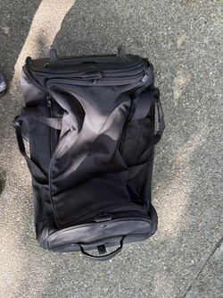 Black rolling duffel bag with multiple compartments.