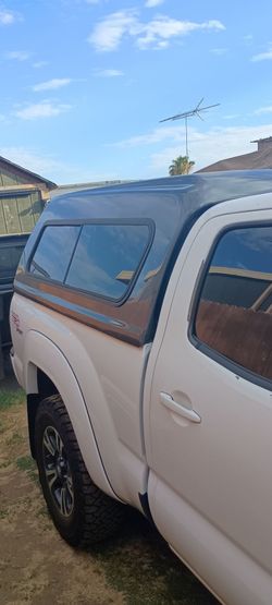 Camper shell Snug Top, Toyota Tacoma 05-15 long bed 6 ft, very spacious and tall very  unique, front window goes down has two latches to secure it