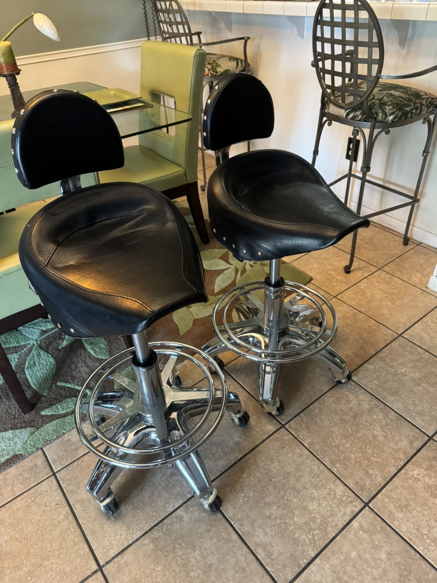 A set of vintage seats, Harley Davidson, motorcycle saddle, seat, and chrome with rolling rolling wheels