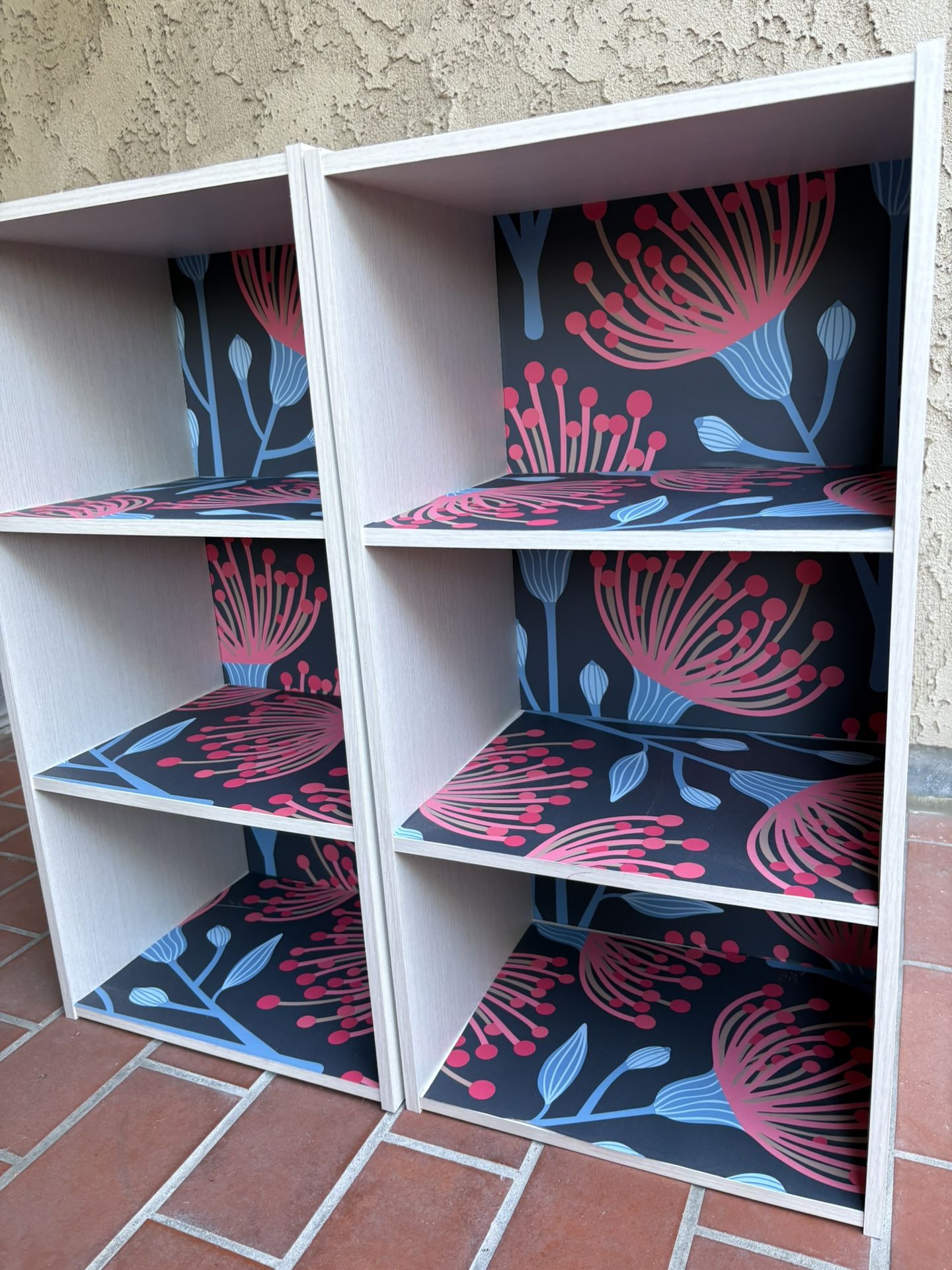 2 Bookshelf Units With Bright Floral Wallpaper Applied