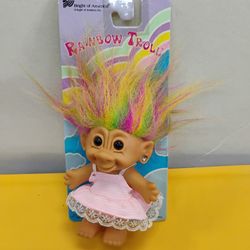 Vintage Bright of America Rainbow Troll doll, featuring rainbow-colored hair and a pink patterned dress.