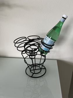 A Black Wine Metal rack that holds up to 6 bottles of wine. It measures 13" tall by 13" in width by 13" deep.