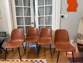 Four brown “leather” dining chairs