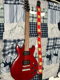 This is a red Ibanez GAX70 Gio series electric guitar.