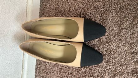 Beige pumps with black cap toes