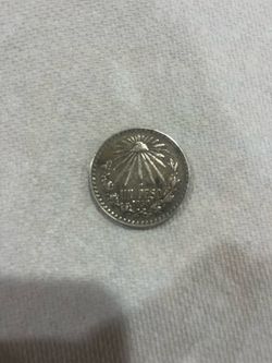 1938 peso Mexico This is a 1938 Mexican One Peso coin, which features the "Liberty Cap" (Gorro Frigio) surrounded by radiant rays on this side.