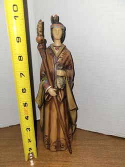 Resin or molded decorative rustic, native, or harvest attire holding a staff & fish. American Indian