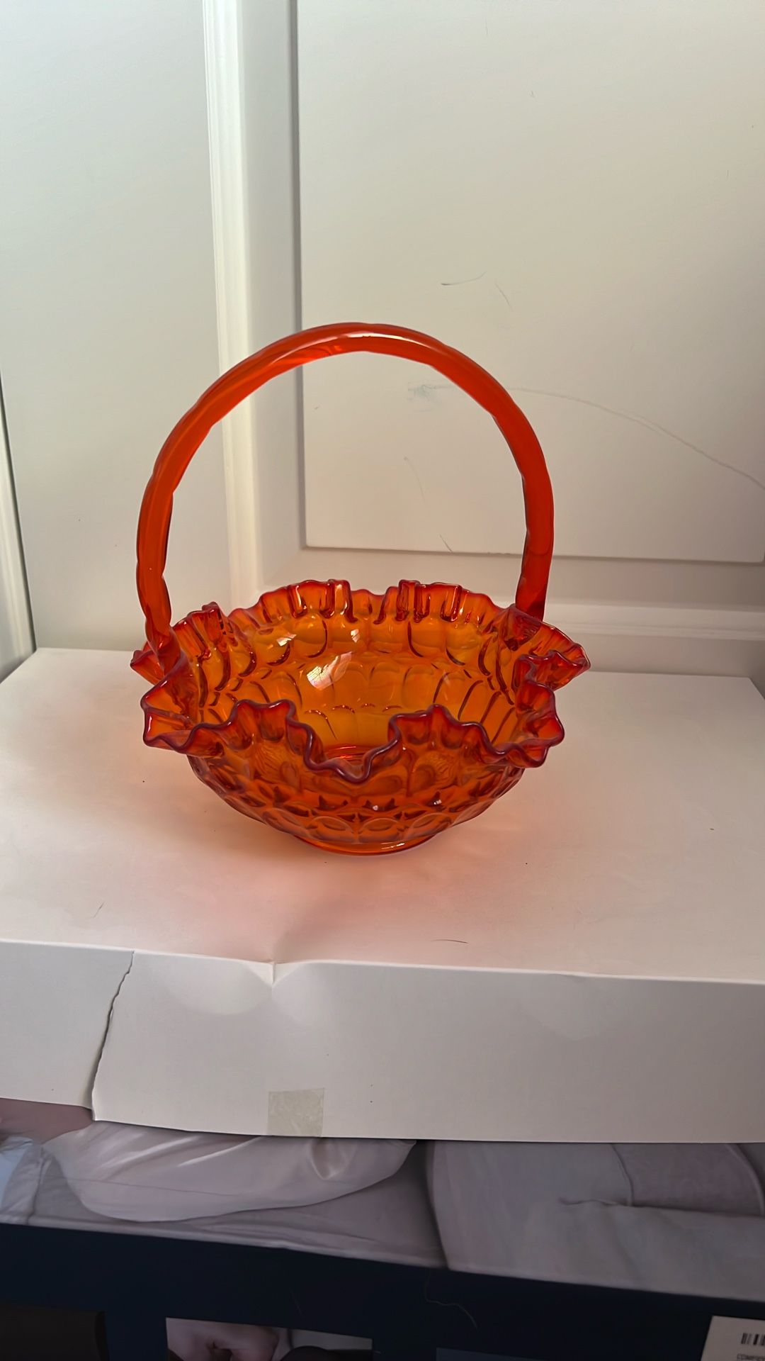 vintage Fenton orange glass basket with a ruffled edge and handle,