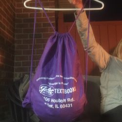 Purple drawstring backpack with writing in front