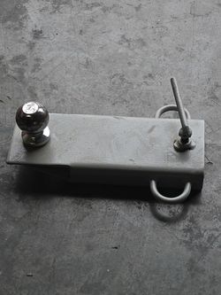 This is a single-fork-mounted trailer hitch attachment (also called a clamp-on forklift tow adapter). It is designed to slide directly over a single p