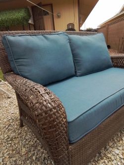 Wicker loveseat with cushions.