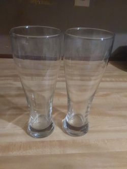 two tall, clear glass tumblers, likely designed for beverages