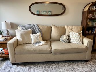 Two piece tan couch with pillows