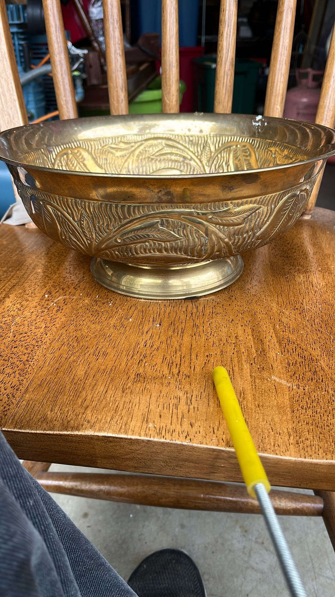 This is a vintage brass bowl, possibly from India, with a decorative design on the exterior. The image shows the underside of the bowl, which has a st
