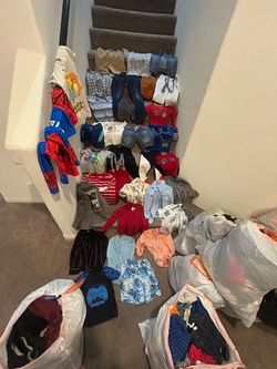 A bunch of kids clothes and shoes different sizes