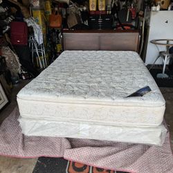  Used queen size pillow-top mattress and box spring set with a wooden headboard. 
