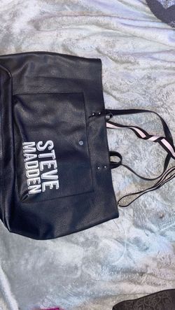 black Steve Madden tote bag featuring bold white brand lettering on the front pocket