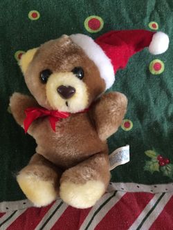 Small stuffed toy teddy bear with Santa hat