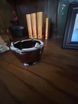 Overview        The selected region shows a vintage brown and white ceramic ashtray, likely featuring a mid-century brown drip glaze style.