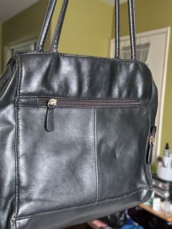 Sleek black leather tote designed for everyday use. Smooth leather exterior with secure zip
