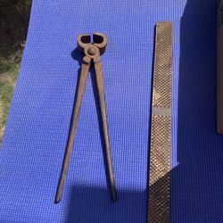  the image is a pair of vintage blacksmith farrier nippers, often used as pull-offs for removing horseshoes. 