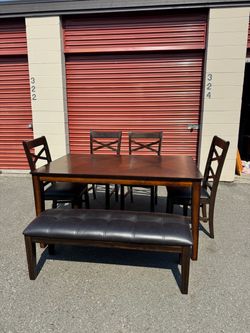 Wooden table and four chairs and a bench