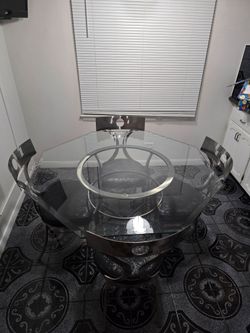 Steel framed table and chairs. Glass table top.